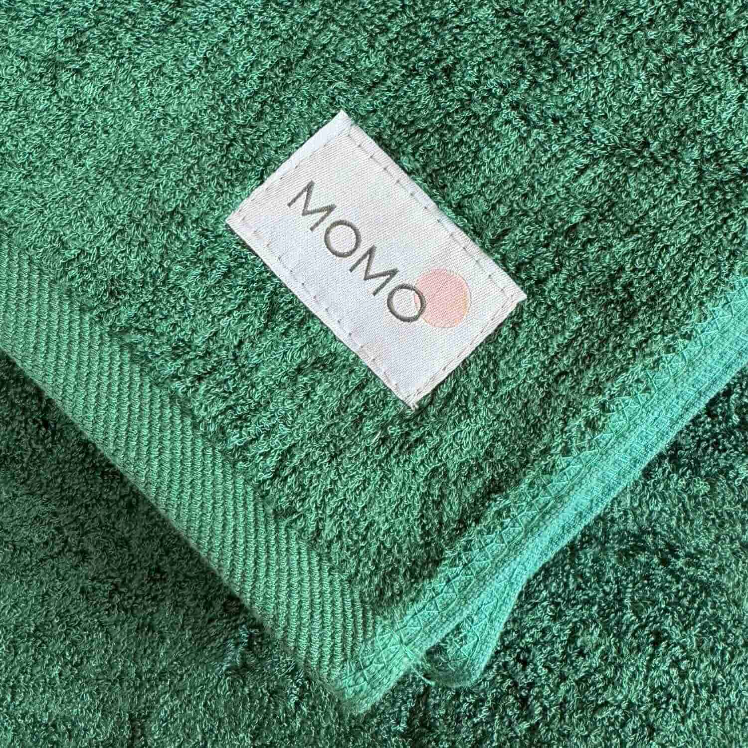 Close-up of green bamboo towel with logo – soft, absorbent and sustainable fabric