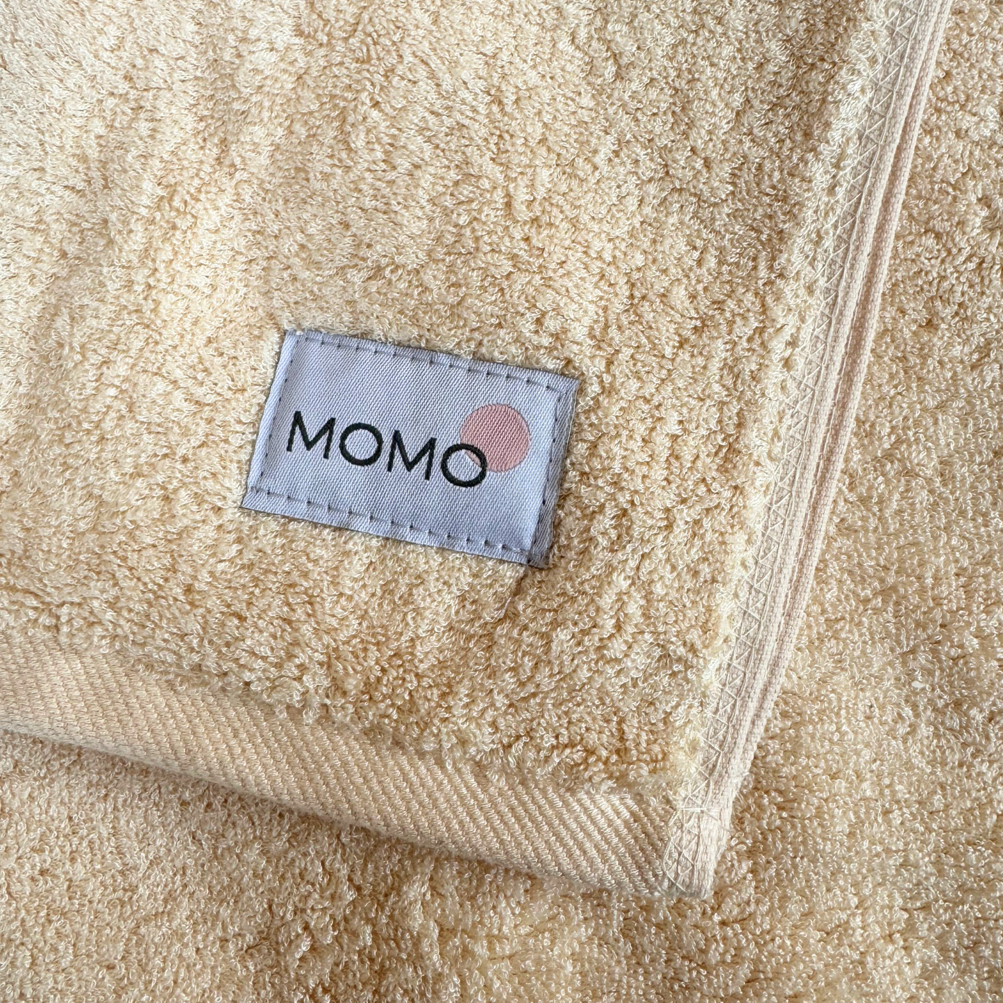 Beige bamboo towel with Momo logo – soft, absorbent and sustainable