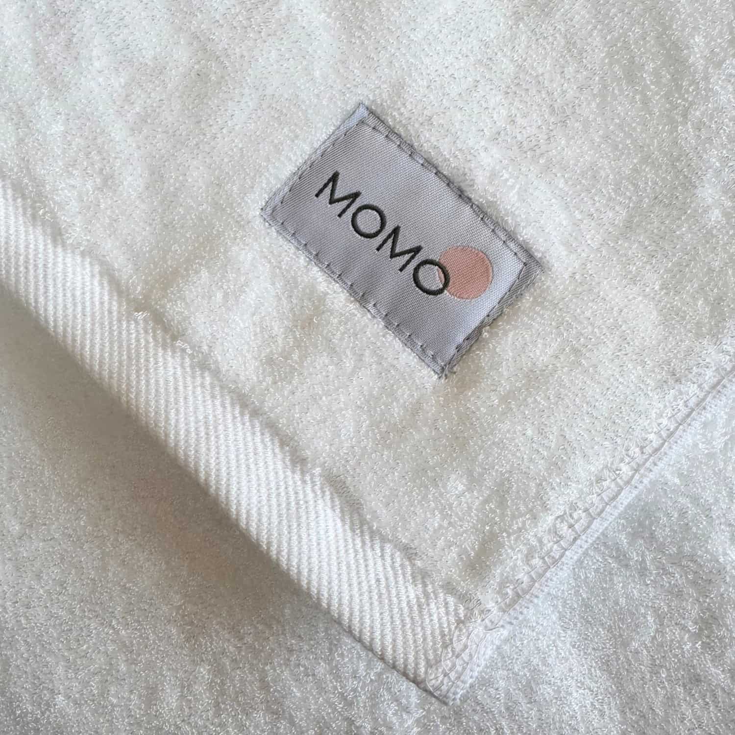 Close-up of Momo label on white bamboo towel – soft, absorbent and sustainable