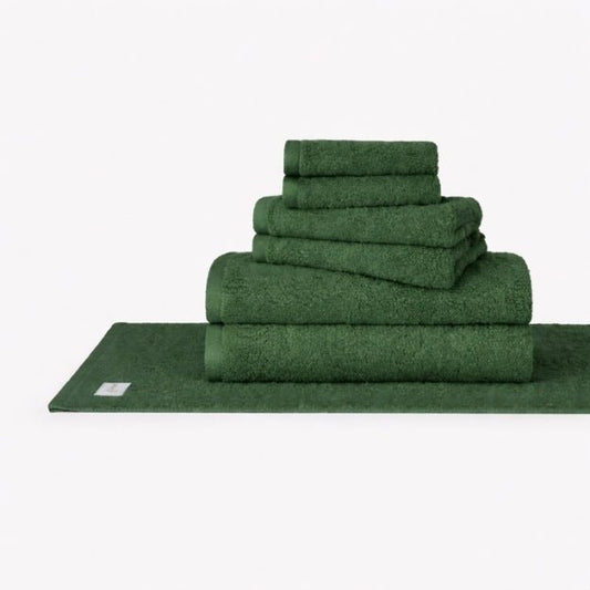 Green Wabi Sabi cotton towel set stacked display showing bath towels, hand towels, and washcloths on white background