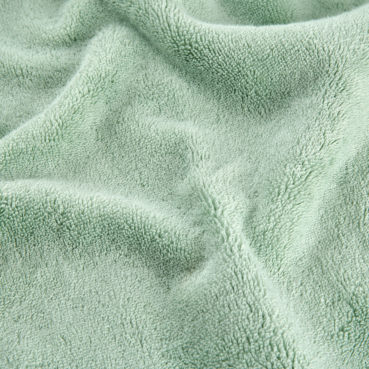 Conjunto de toalhas de bambu verde mostrando detalhe da textura macia do tecido em vista aproximada