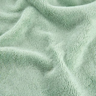 Conjunto de toalhas de bambu verde mostrando detalhe da textura macia do tecido em vista aproximada