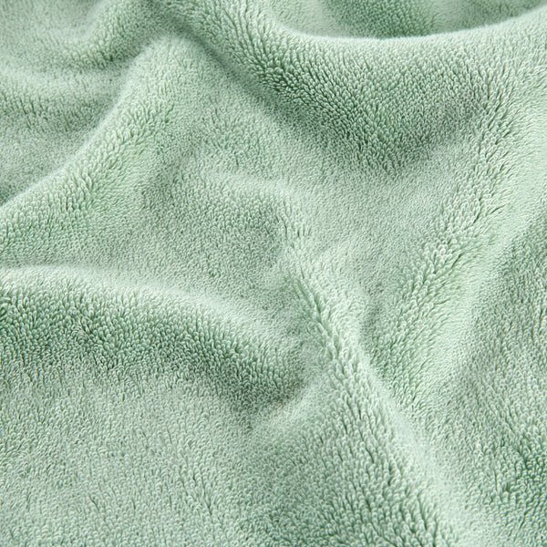 Conjunto de toalhas de bambu verde mostrando detalhe da textura macia do tecido em vista aproximada