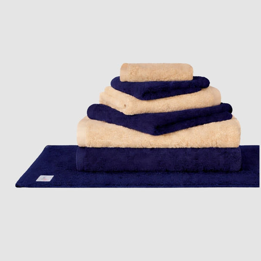 Wabi Sabi towel set in navy blue and beige arranged in stacked display on gray background