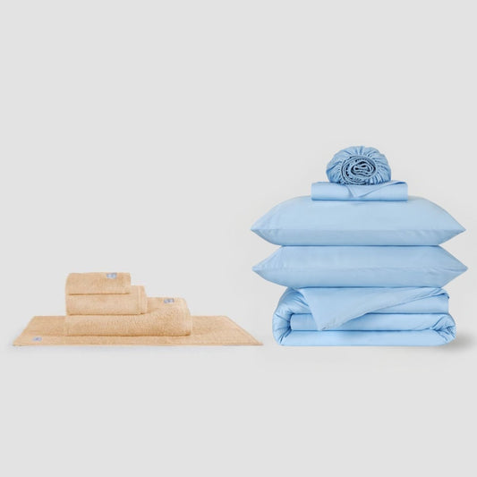 Conjunto de toalha bege e jogo de cama azul empilhados lado a lado, Momo Cotton