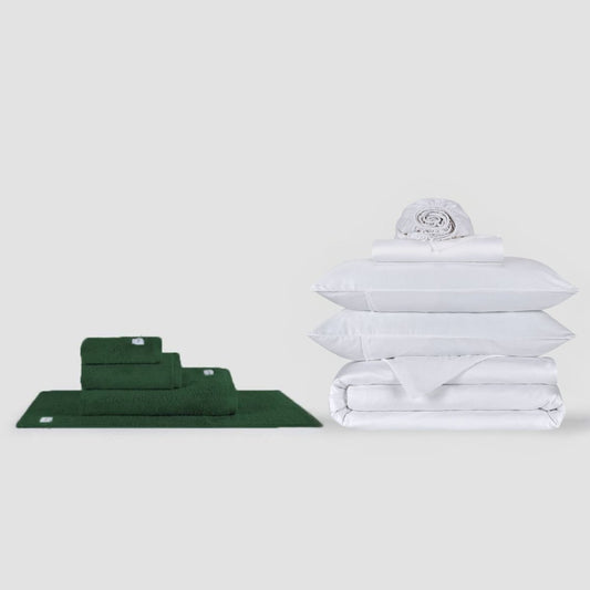 Conjunto de toalhas verde e jogo de cama branco empilhados em fundo branco por Momo Cotton