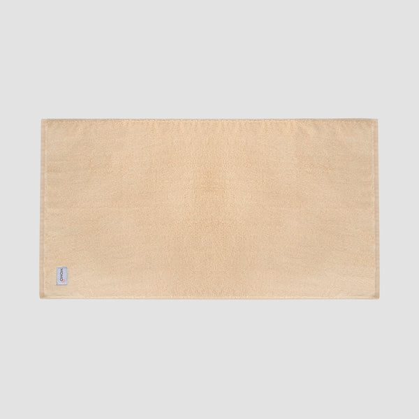Tapete de banho bege em bambu da Momo Cotton – suave, absorvente, seca rapidamente e sustentável.